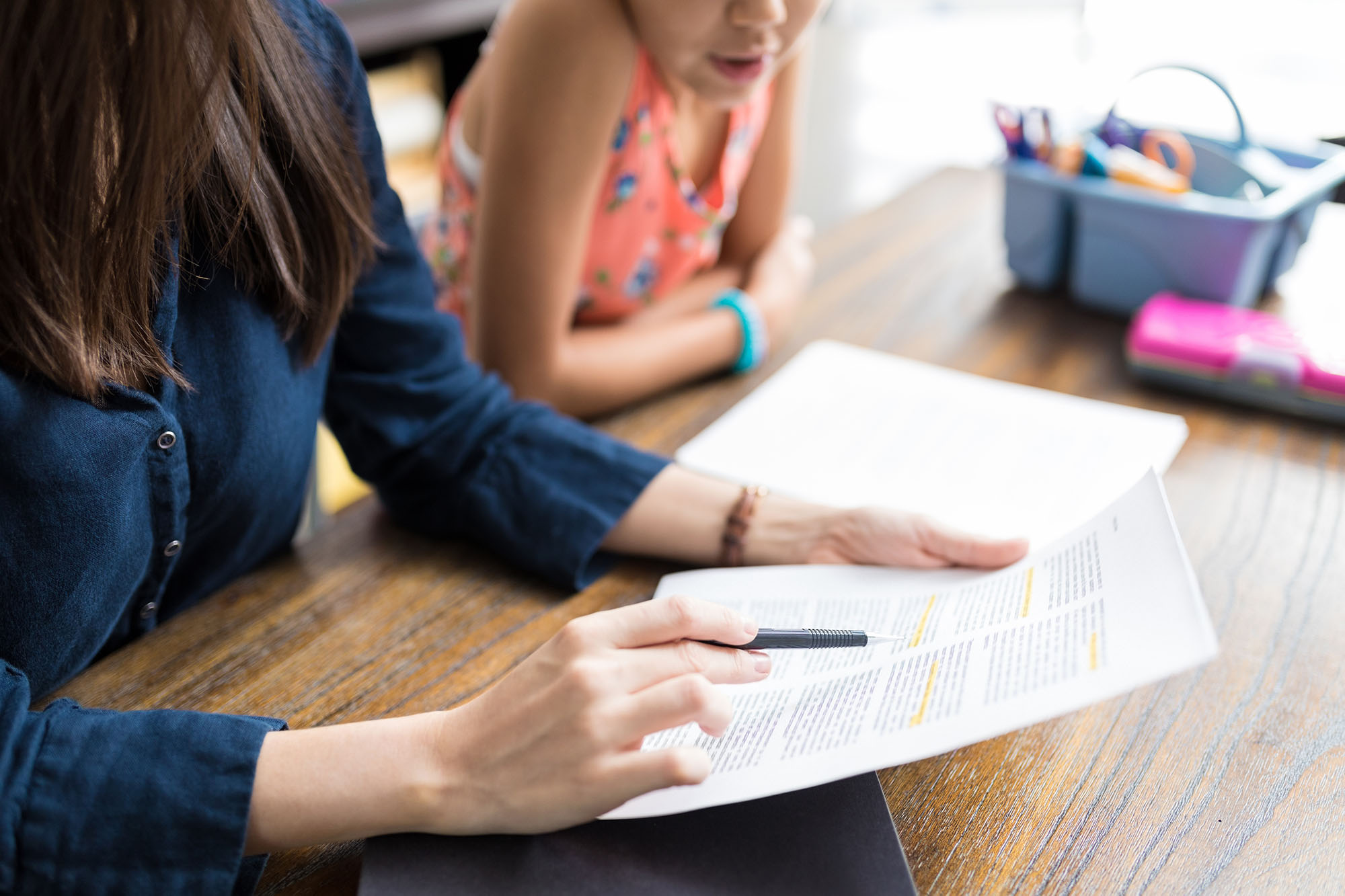 Mother With School Notes Teaching Daughter At Table